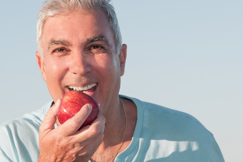 Smiling man biting into apple
